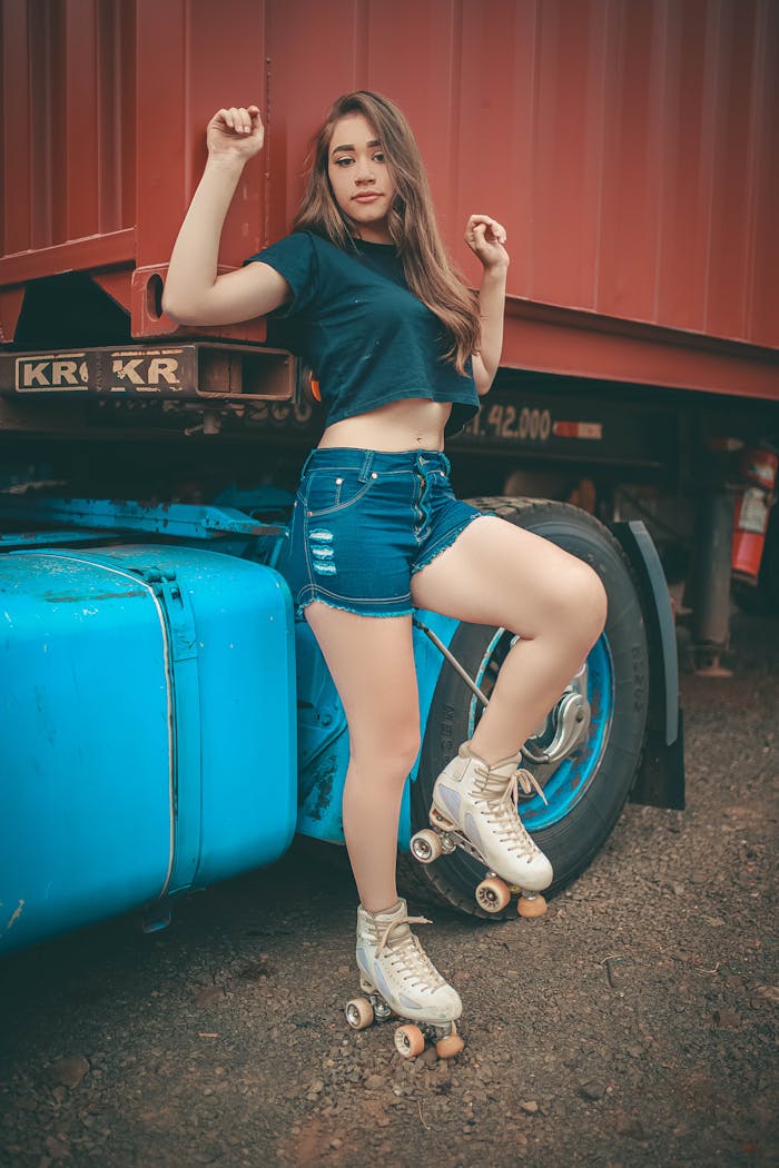 Young woman posing stylishly on roller skates beside a truck.